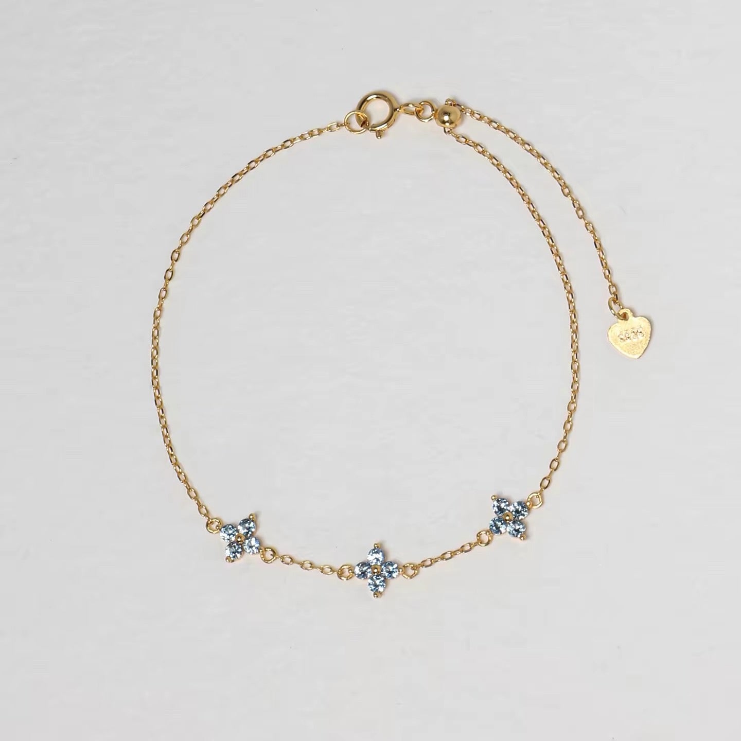 Clover Bracelet in gold with three pale blue four-petal floral stones