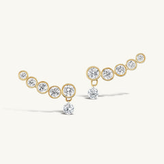 Line Earrings in gold with five graduated bezel-set zirconia stones and a dangling round stone